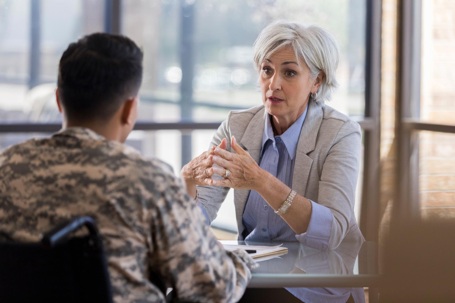 Concerned therapist talks with young soldier